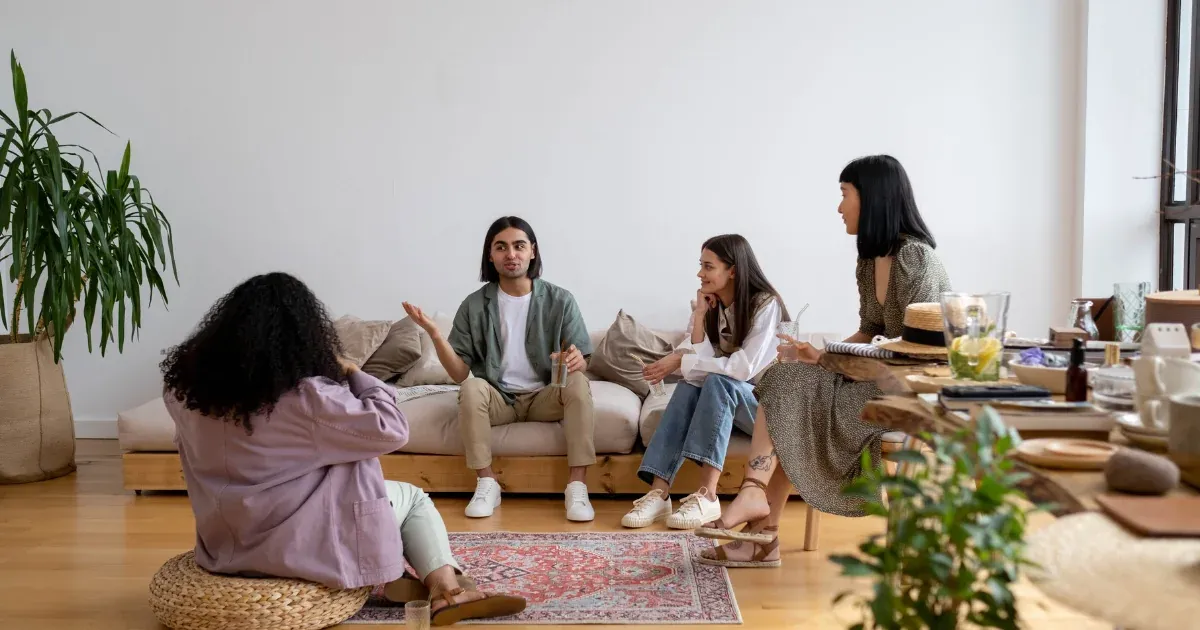 A group of people sitting and talking in a living area of a house
